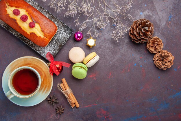 Torta squisita vista dall'alto con una tazza di tè sulla superficie scura torta biscotti allo zucchero torta biscotto dolce tè