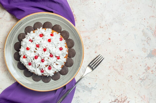 Torta vista dall'alto con crema pasticcera su forchetta scialle viola piatto