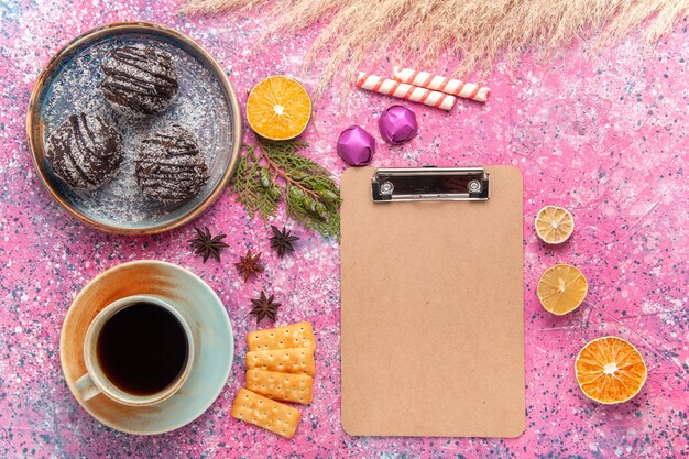 Torte al cioccolato vista dall'alto con una tazza di tè su rosa chiaro