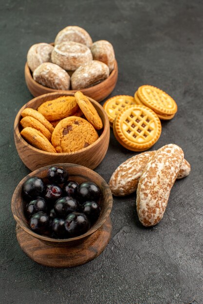 Torte dolci di vista frontale con i biscotti e le olive sulla torta torta di superficie scura dolce