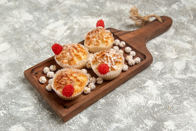 Torte dolci vista frontale con caramelle sulla superficie bianca