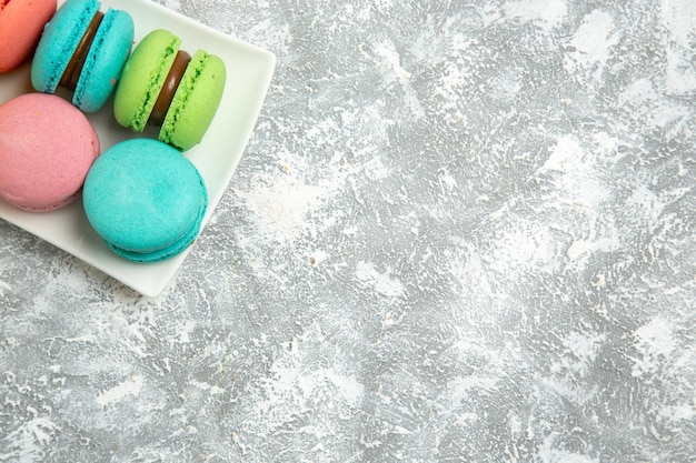 Torte piene di macarons francesi vista dall'alto su superficie bianca chiara