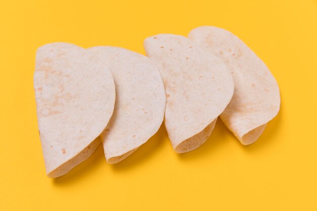 Tortillas ad alto angolo su sfondo giallo