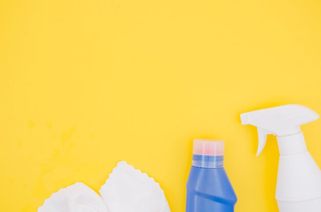 Tovagliolo bianco; flacone spray e detergente bottiglia blu con copia spazio per scrivere il testo su sfondo giallo