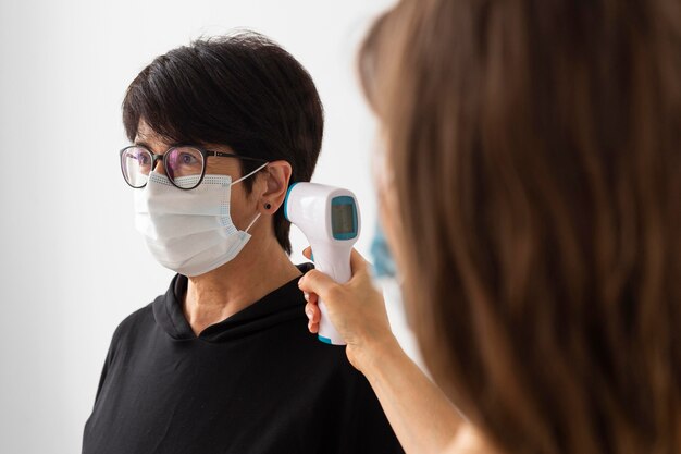 Trainer che esamina la temperatura di una donna