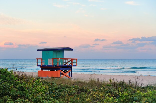 Tramonto di Miami South Beach con torre del bagnino e costa con nuvole colorate e cielo blu.