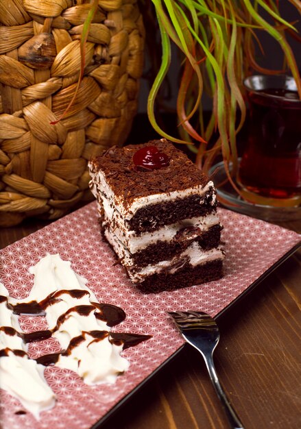 Trancio di tiramisù a base di cioccolato e spugna bianca. Un pezzo di dessert su tavole di legno.