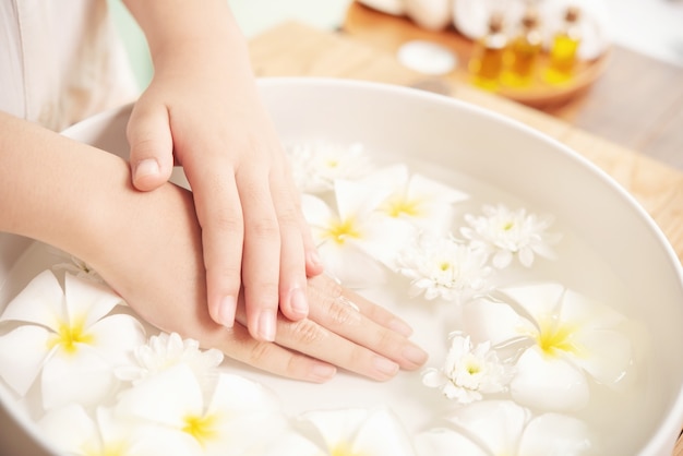 Trattamento e prodotto termale. fiori bianchi in una ciotola di ceramica con acqua per aromaterapia presso la spa.