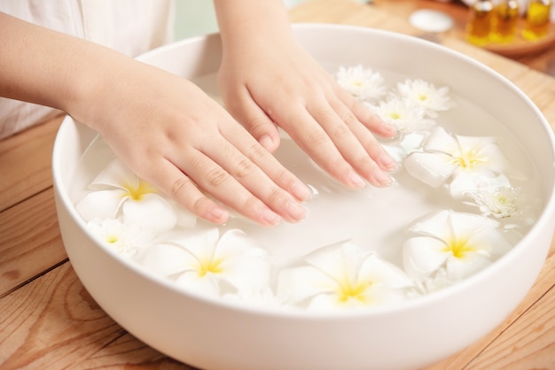 Trattamento e prodotto termale. fiori bianchi in una ciotola di ceramica con acqua per aromaterapia presso la spa.