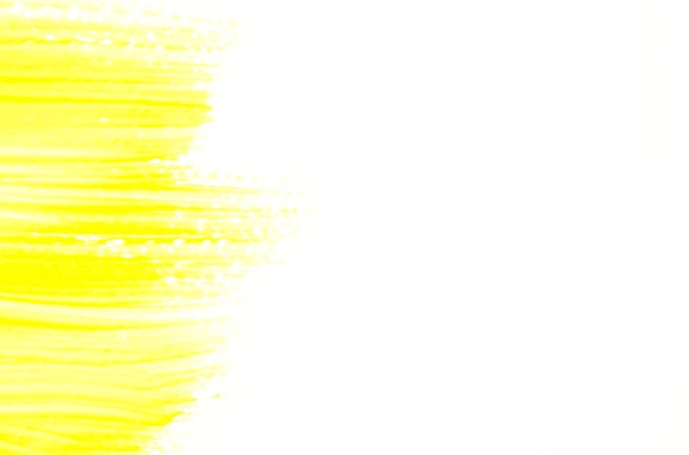 Tratto di pennello giallo su tela bianca