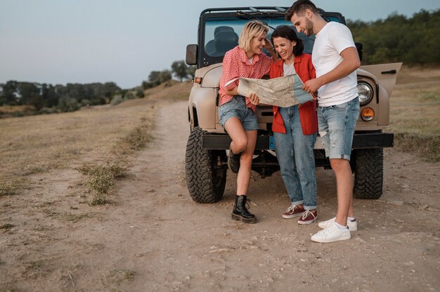 Tre amici che controllano la mappa mentre viaggiano in macchina insieme