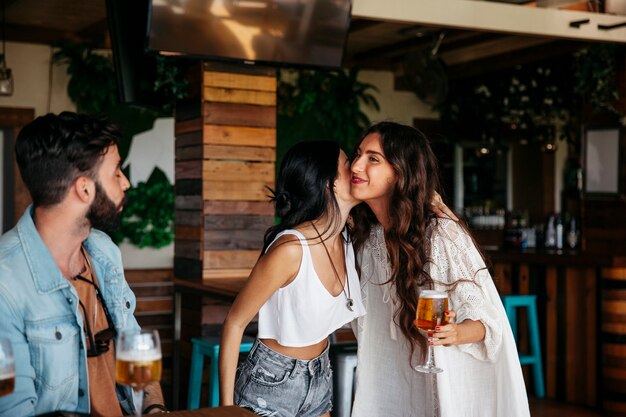 Tre amici che dicono ciao in bar