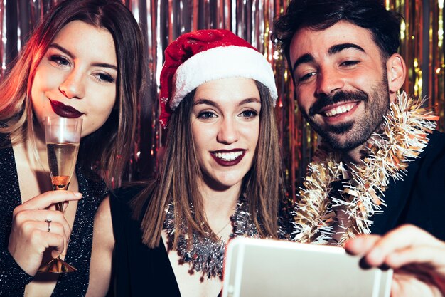 Tre amici che prendono selfie per il partito di nuovi anni