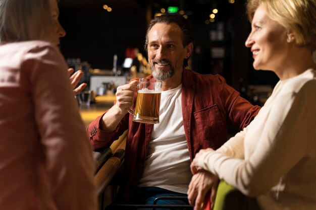 Tre amici più grandi che parlano e bevono in un ristorante