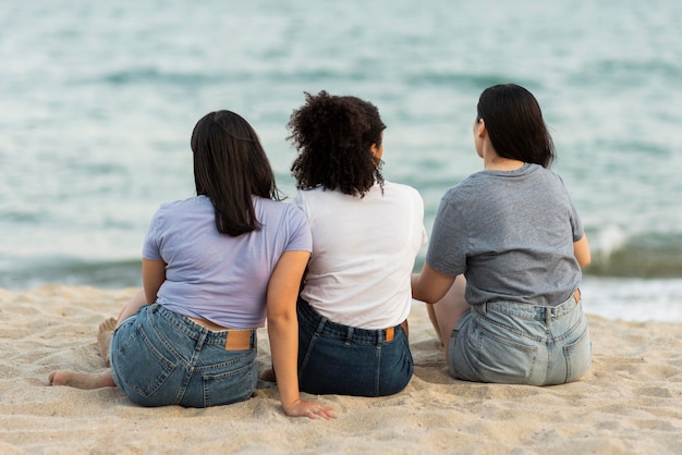 Tre amici seduti sulla spiaggia