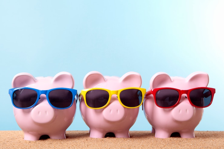 Foto gratuito tre banche piggy su una spiaggia