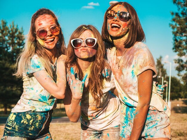 Tre belle ragazze felici che fanno festa al festival di colori di Holi