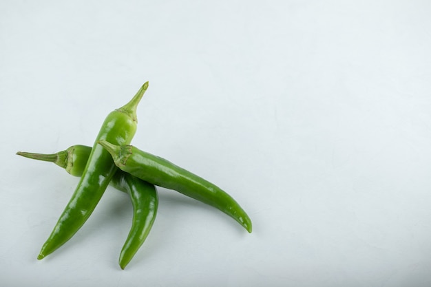 Tre colpi di peperoncino su sfondo bianco.