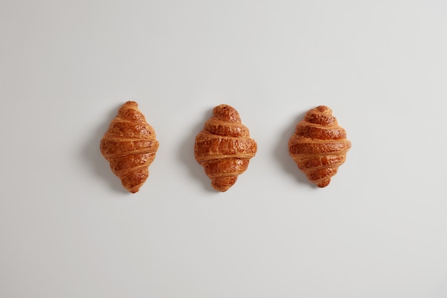 Tre deliziosi cornetti con marmellata per la tua colazione quotidiana. Prodotto da forno francese classico tradizionale. Varietà di pasta sfoglia fatta in casa. Dolciumi freschi. Cibo spazzatura e concetto di calorie.