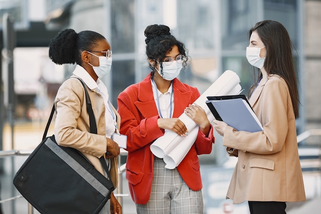 Tre donne che lavorano come architetto in una costruzione. Persone che prendono una decisione sul piano di un edificio. Concetto di quarantena