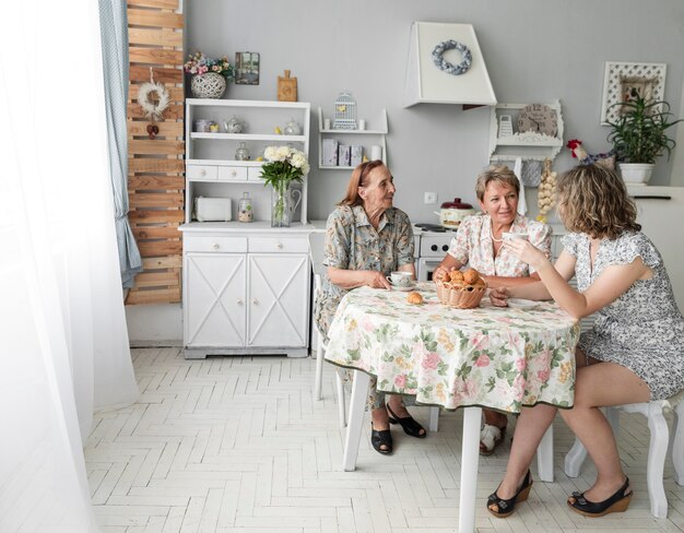 Tre donne di generazione che discutono qualcosa durante la prima colazione