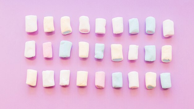 Tre file di marshmallow su sfondo rosa