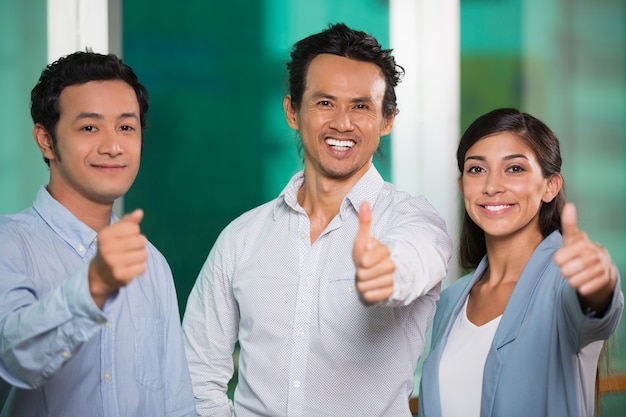 Tre gente di affari sorridere mostrando pollice in alto