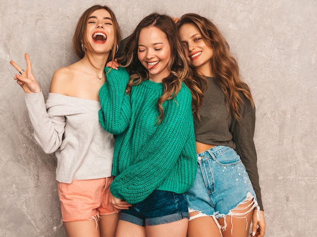 Tre giovani belle ragazze sorridenti splendide in abiti estivi alla moda. Posa sexy spensierata delle donne. Modelli positivi che si divertono