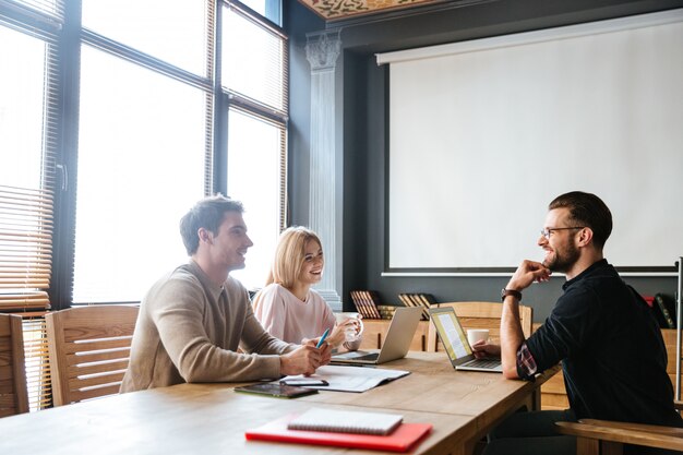 Tre giovani colleghi felici coworking