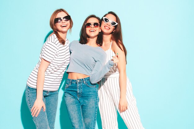 Tre giovani e belle donne hipster sorridenti con gli stessi vestiti estivi alla moda