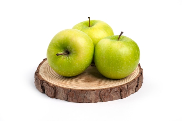 Tre mele fresche sul pezzo di legno.