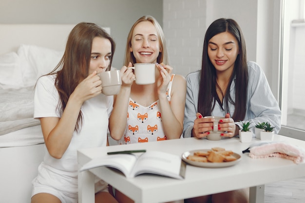 Tre ragazze fanno festa in pigiama a casa