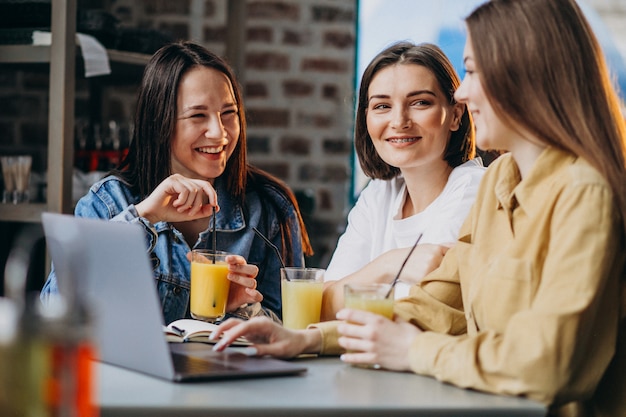 Tre studenti che si preparano per l'esame con il computer portatile in un caffè