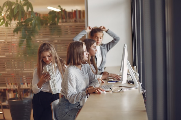 Tre studenti seduti al tavolo in una classe