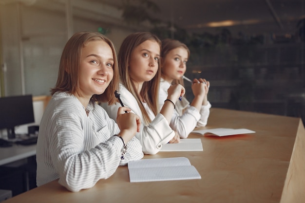 Tre studenti seduti al tavolo in una classe