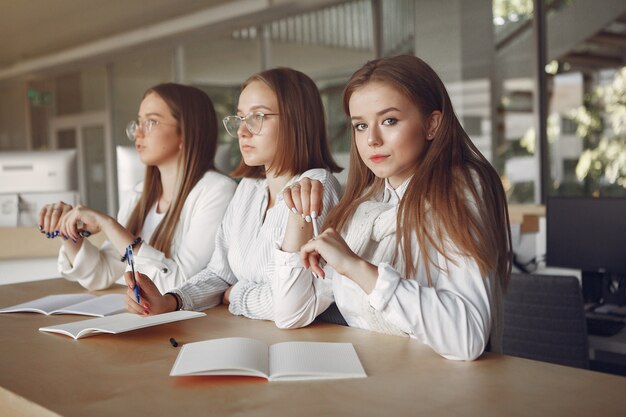 Tre studenti seduti al tavolo in una classe