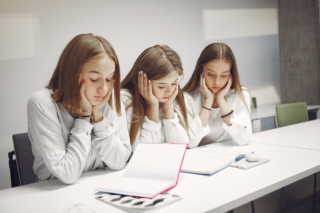 Tre studenti seduti al tavolo in una classe