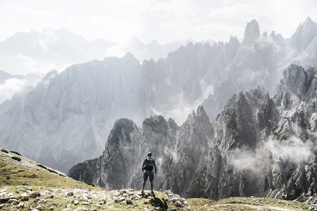 Trekker con uno zaino che si gode una vista sulle montagne nebbiose