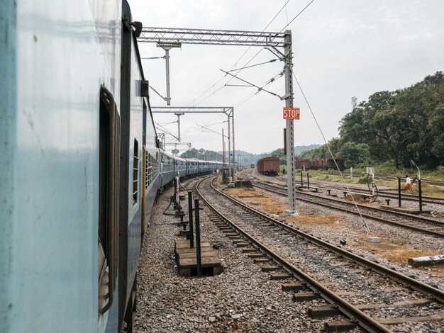 Treno che passa in una stazione ferroviaria su uno sfondo di ferrovia