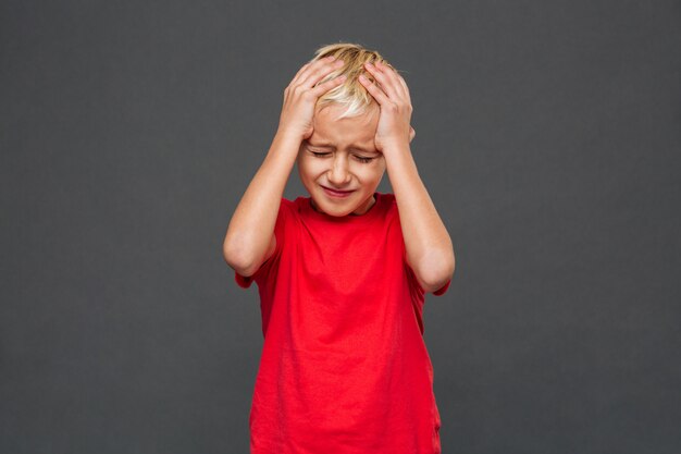 Triste bambino ragazzo con mal di testa