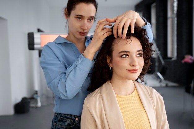 Truccatrice che prepara la modella per il servizio fotografico