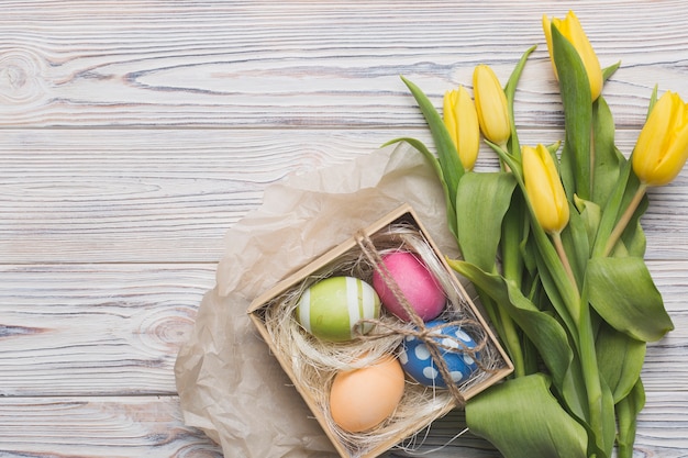 Tulipani e uova su fondo in legno