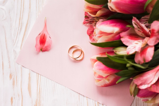 Tulipani sul tavolo accanto a anelli di fidanzamento