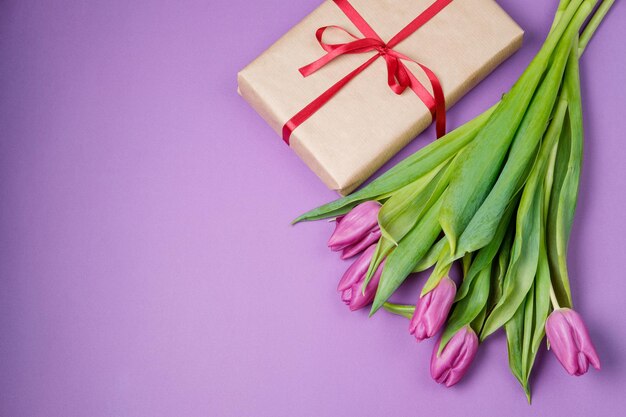 Tulipani viola caffè e dolci su sfondo viola Concetto di primavera Vista dall'alto spazio piatto per la copia