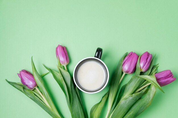 Tulipani viola e caffè su sfondo verde Concetto di primavera Vista dall'alto spazio piatto per la copia