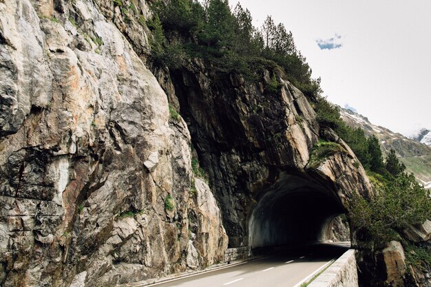 Tunnel di auto in roccia sulla strada in alto nelle Alpi svizzere