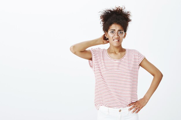 Turbata donna incerta con acconciatura afro in posa in studio