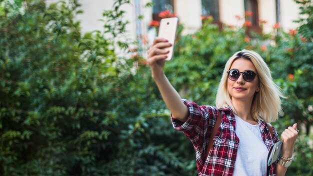 Turista bionda prendendo selfie