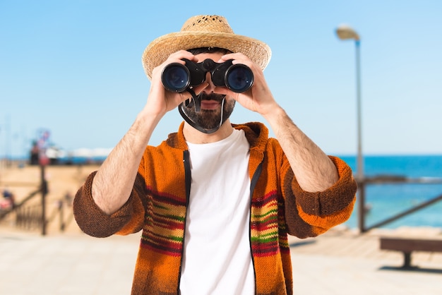 Turista con il binocolo su priorità bassa bianca