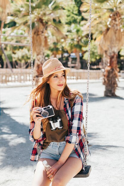 Turista con la macchina fotografica sull&#39;altalena